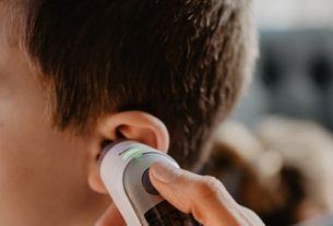 man holding white and gray bottle